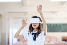 青年女性戴VR眼镜体验虚拟现实游戏场景