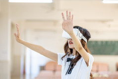青年女性戴VR眼镜体验虚拟现实游戏场景