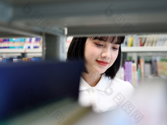 图书馆看书的女<strong>大</strong>学生学习阅读书写作业