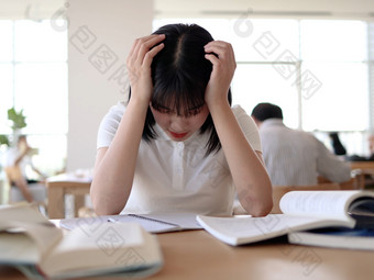 图书馆看书的女大学生学习阅读书写作业