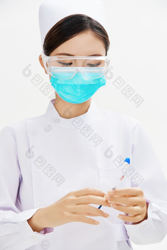 穿护士服戴口罩手执针筒的年轻女护士