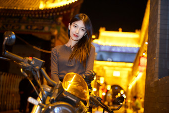 夜晚古城景区骑摩托的少女