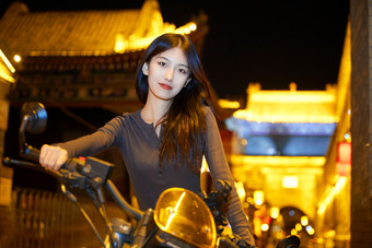 夜晚古城景区骑摩托的少女