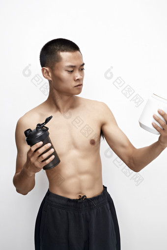 手持<strong>蛋白粉</strong>的身材匀称肌肉扎实的亚洲男性