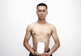 手持<strong>蛋白粉</strong>的身材匀称肌肉扎实的亚洲男性