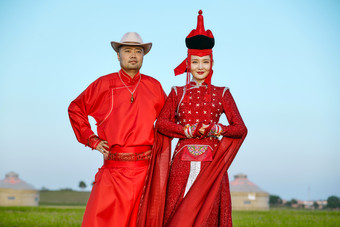 草原上蒙古包前穿蒙古族传统服饰的年轻夫妻