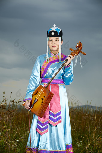草原上穿蒙古族服饰拉<strong>马头</strong>琴的蒙族女乐手