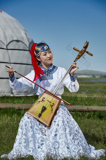 蒙古包前穿蒙古族服饰拉<strong>马头</strong>琴的蒙族女乐手