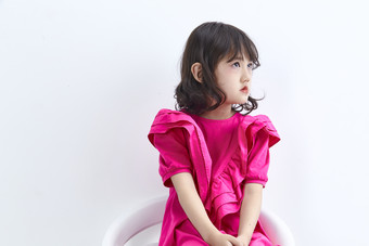 白色背景里坐在凳子上的可爱的亚洲小女孩儿童