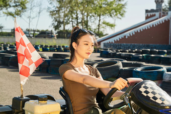 在游乐场卡丁赛道上驾驶卡丁车的美女