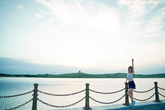 盛夏夕阳晚霞湖边码头看风景的少女