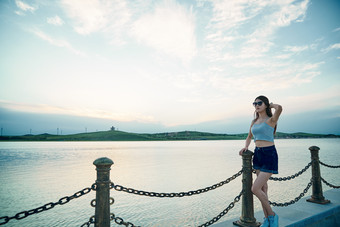 盛夏夕阳晚霞湖边码头看风景的少女