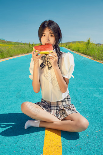 夏日户外湖边彩色公路上玩耍吃西瓜的少女