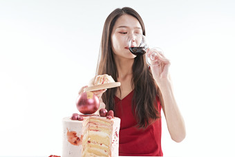喝红酒品尝蛋糕的年轻女性