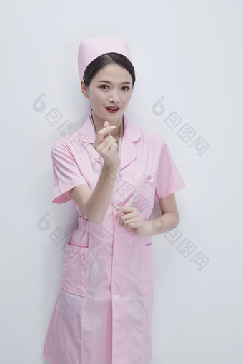 身穿粉色<strong>护士</strong>服佩戴听诊器的女性医护人员