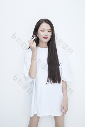 吃西梅的身穿白色长T血衬衫的长发少女人像