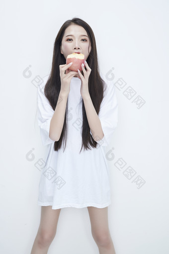 吃苹果的穿白色长T血衫的长发可爱少女人像