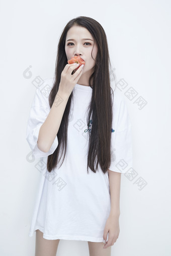 吃番茄的身穿白色长T血衬衫的长发少女人像