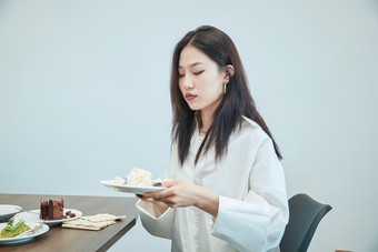 在烘焙店吃蛋糕喝饮料的可爱亚洲少女