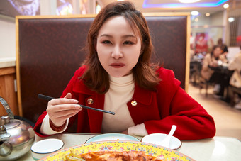 在餐厅吃美味新疆<strong>大盘</strong>鸡的亚洲少女