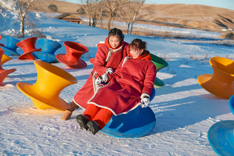 在冰天<strong>雪地</strong>玩耍雪上娱乐载具车辆的闺蜜少女