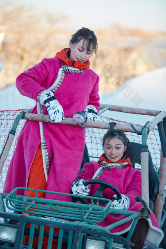 在冰天雪地玩耍雪上娱乐载具车辆的闺蜜少女