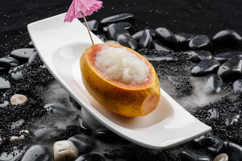 木瓜炖雪蛤摆放在干冰缭绕的鹅卵石上