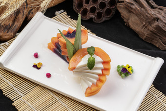 长方形瓷盘装的木瓜蛋白摆放在寿司帘上