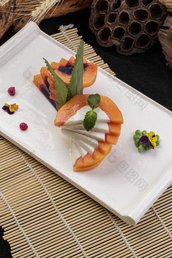 长方形瓷盘装的木瓜蛋白摆放在寿司帘上