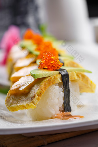烧蛋蟹子芒果手握寿司摆放在寿司帘上