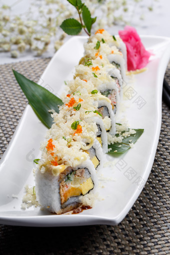 长方形瓷盘装的脆脆卷寿司摆放在餐垫上