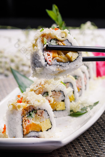 长方形瓷盘装的脆脆卷寿司摆放在餐垫上