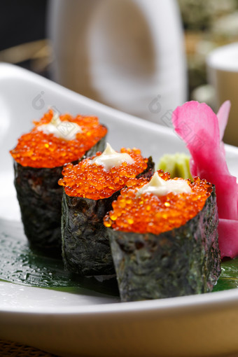鹅颈瓷盘装的蟹子军舰手握寿司摆放在石头上