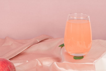 一杯新鲜桃汁粉色背景