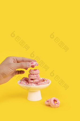 手拿粉色甜甜圈美食糕点