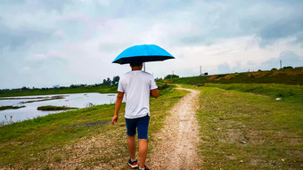 郊外行人雨天撑伞看风景