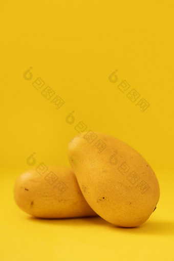 两颗<strong>芒果</strong>黄色背景水果图片