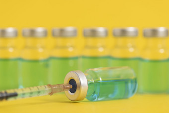 排列整齐的疫苗药瓶黄色背景