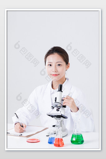 女实验人员使用显微镜记录现象摄影图片