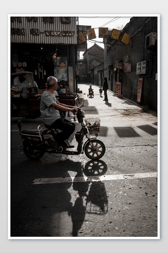 暗调古城旅行旅拍自行车夕阳行人素材摄影图图片