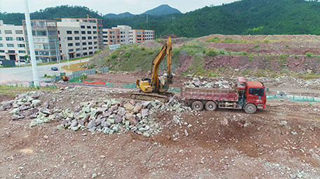 挖掘机工作现场管道铺设石头运货航拍视频