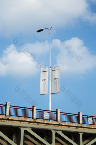 蓝天白云桥梁上的道旗吊旗海报展示道旗样机图片