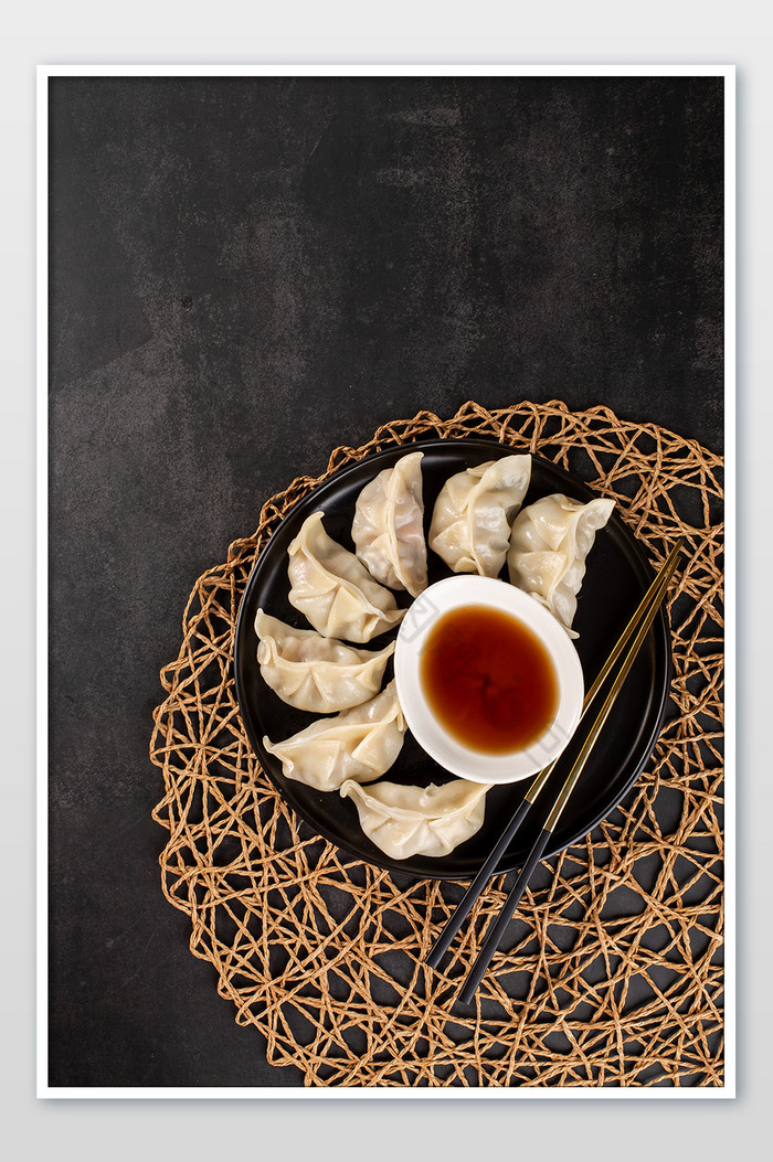一盘新鲜蒸饺放在黑色背景上图片图片