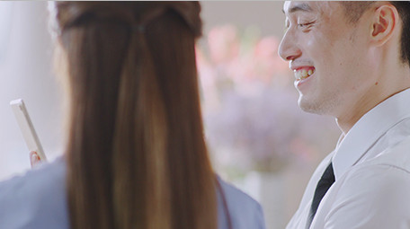 商务西装男女指点微笑实拍特写室内