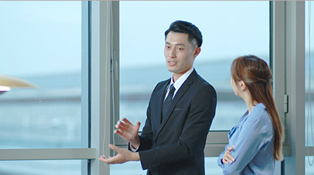 商务西装男女窗边指点点头室内实拍