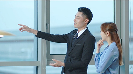 商务西装男女窗边指点点头室内实拍