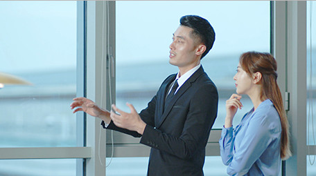 商务西装男女窗边指点点头室内实拍