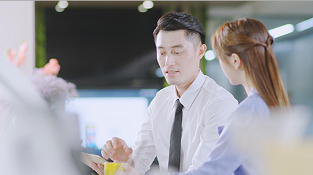 商务西装男女指点微笑近景喝东西实拍