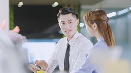 商务西装男女指点微笑近景喝东西实拍