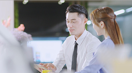 商务西装男女指点微笑近景喝东西实拍